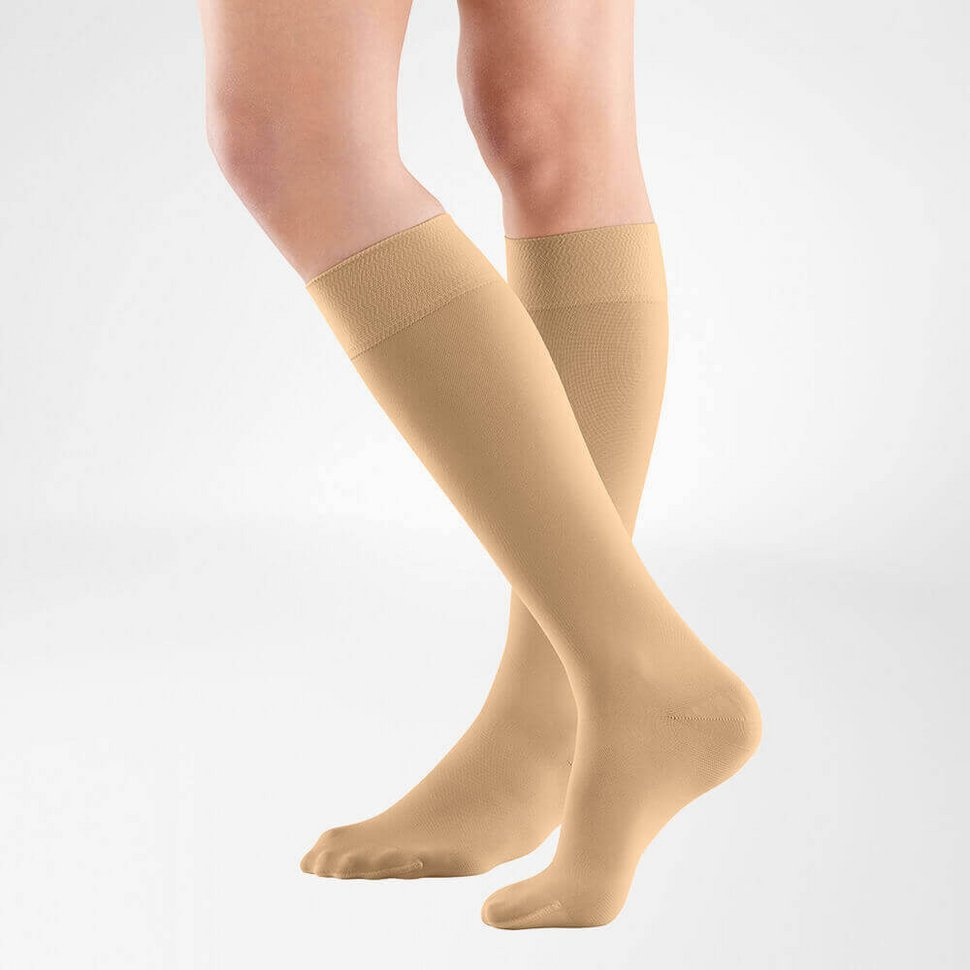 the knee high bauerfeind medical venotrain soft compression stockings in color caramel worn by a person on a white background