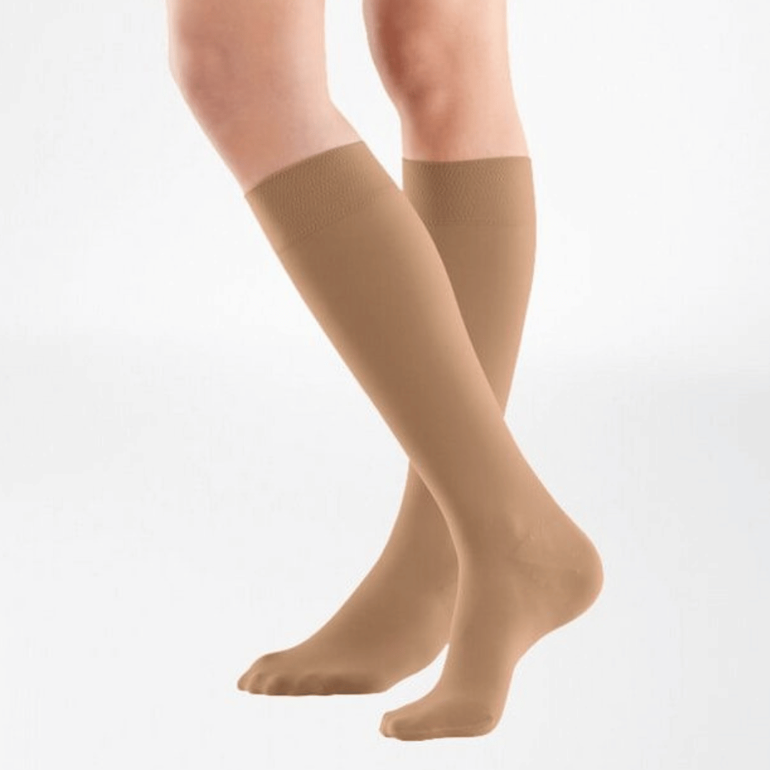 the knee high bauerfeind medical venotrain soft compression stockings in color cashew worn by a person on a white background