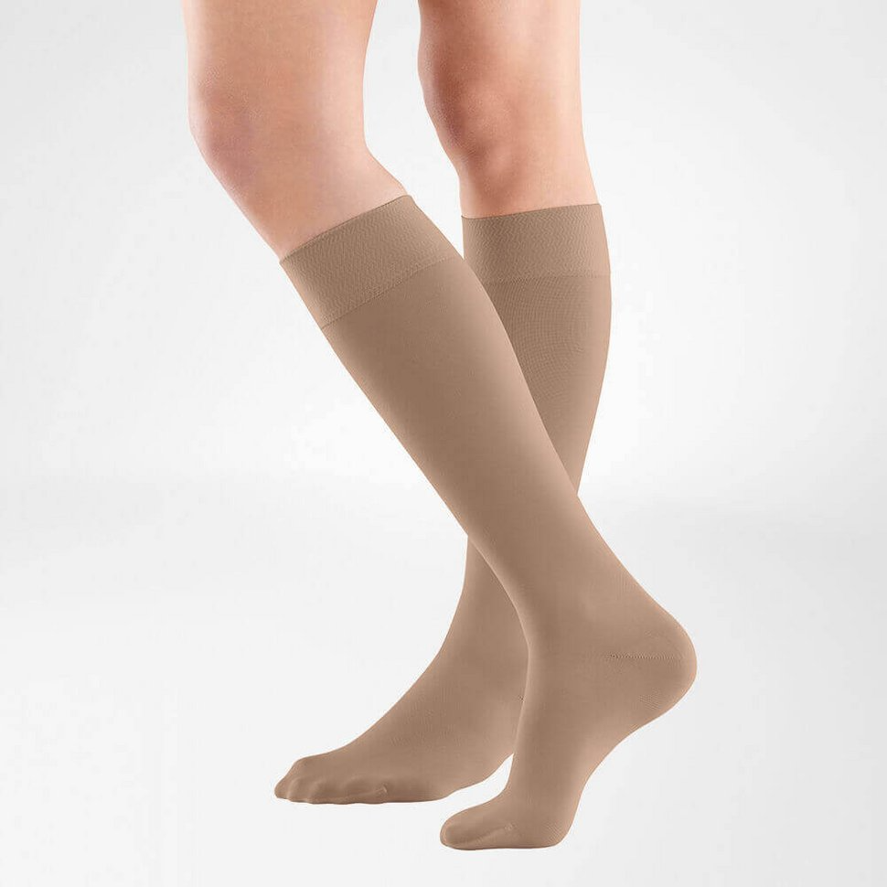 the knee high bauerfeind medical venotrain soft compression stockings in color amaretto worn by a person on a white background