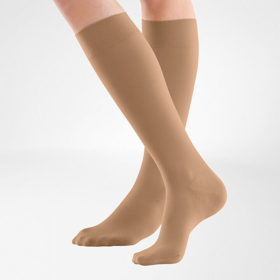 the knee high bauerfeind medical venotrain soft S compression stockings in color cashew worn by a person on a white background
